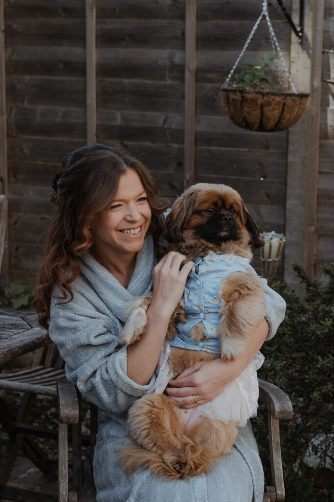 charlotte holding her dog, who is wearing a dress