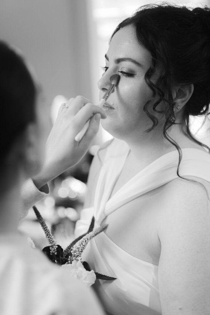 black and white bridal portrait with make-up being applied 