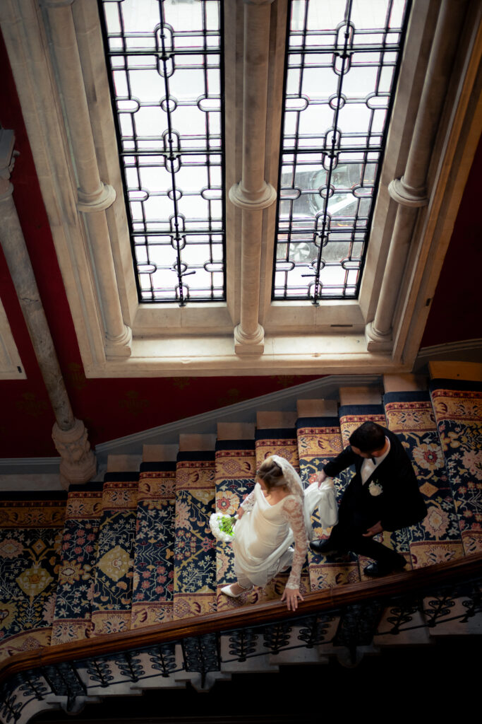 birds eye view of bride and groom walking down the grand staircase at St Pancras Renaissance Hotel 