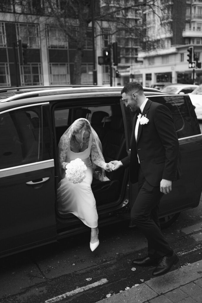 groom helping bride out of uber