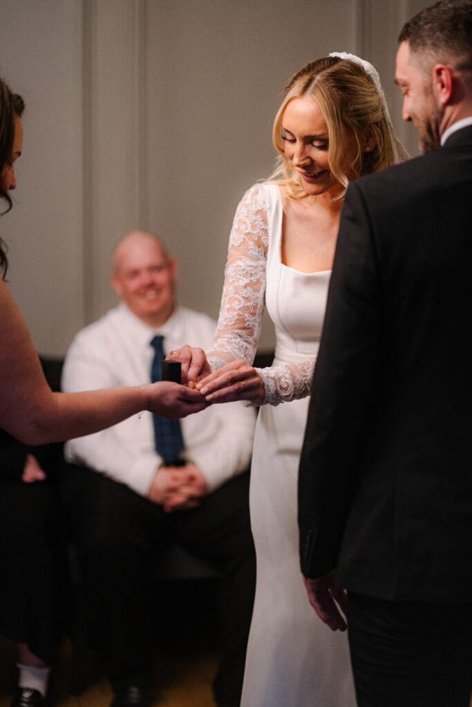 bride putting on ring during elopement ceremony