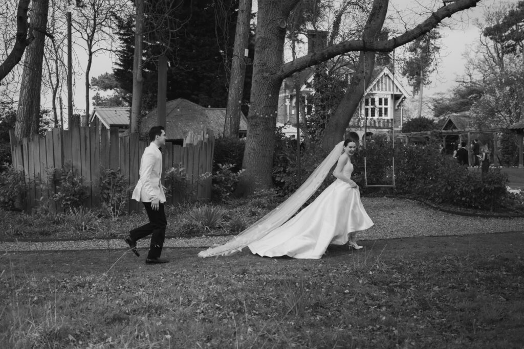 bride and groom running on the lawn at baddow park house during spring wedding